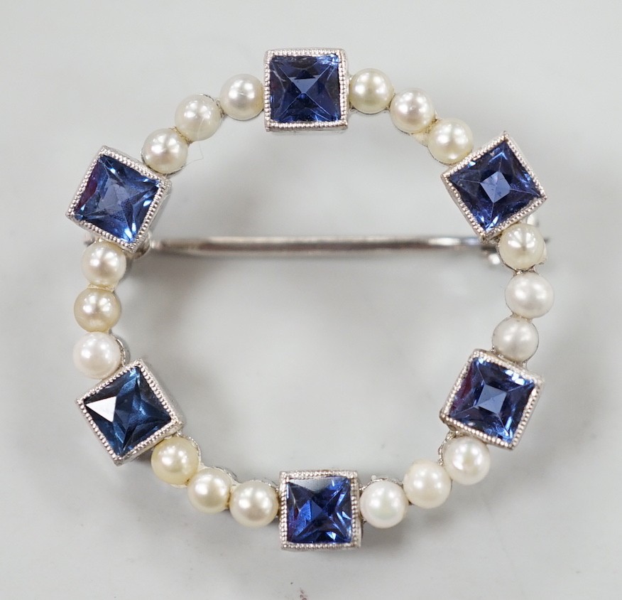 An 18k white metal, synthetic blue spinel? and seed pearl set openwork brooch, 24mm, gross weight 3 grams.